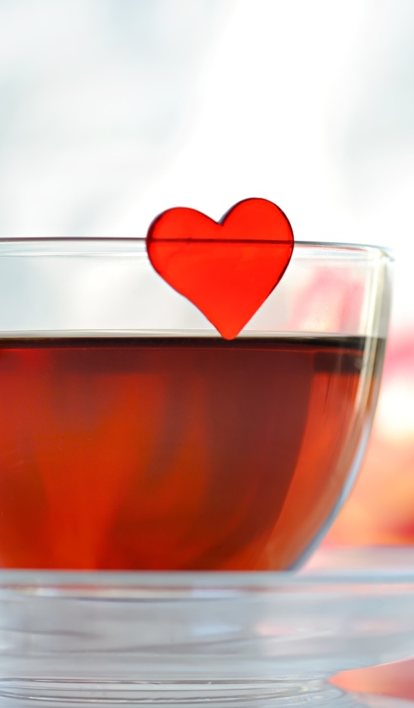 Маленькое красное сердечко в стеклянной чашке с чаем