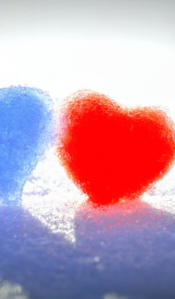 Голубое и красное сердце на белом снегу 