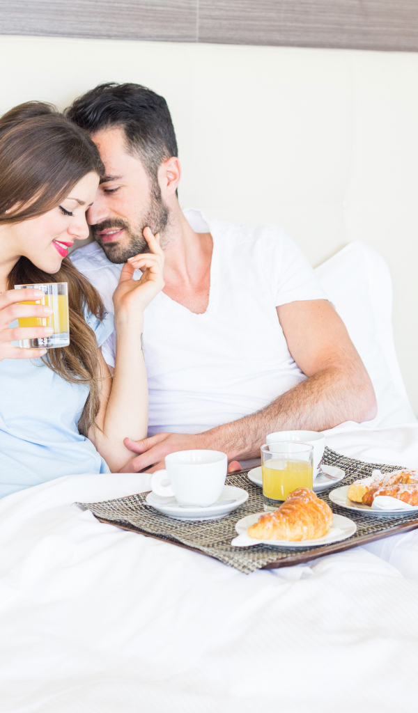 Влюбленная пара с завтраком в постели