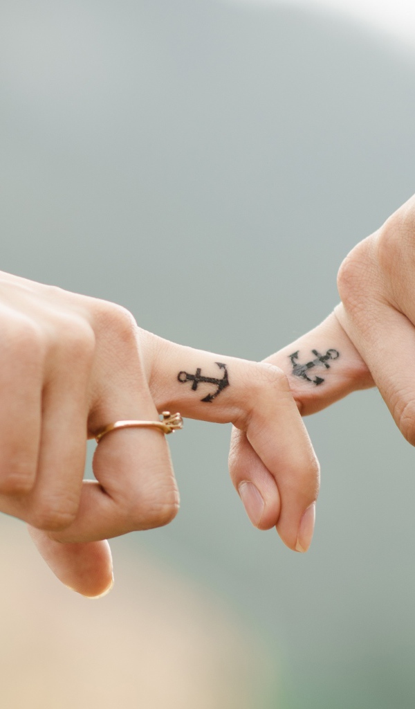 Руки влюбленной пары с татуировками на руках 