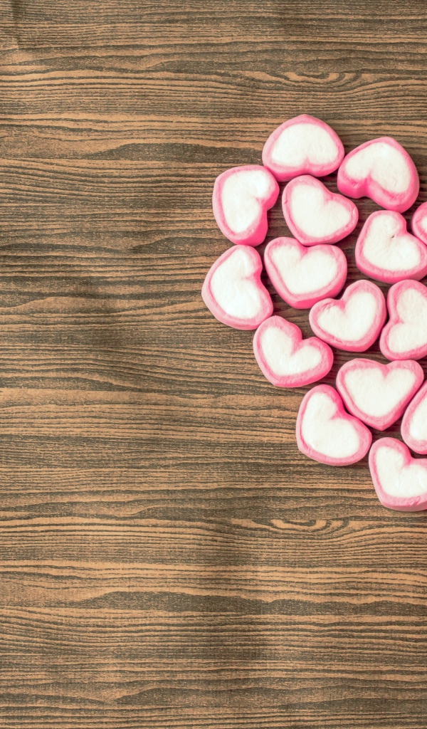 Сердце из конфет в форме сердца на деревянном столе