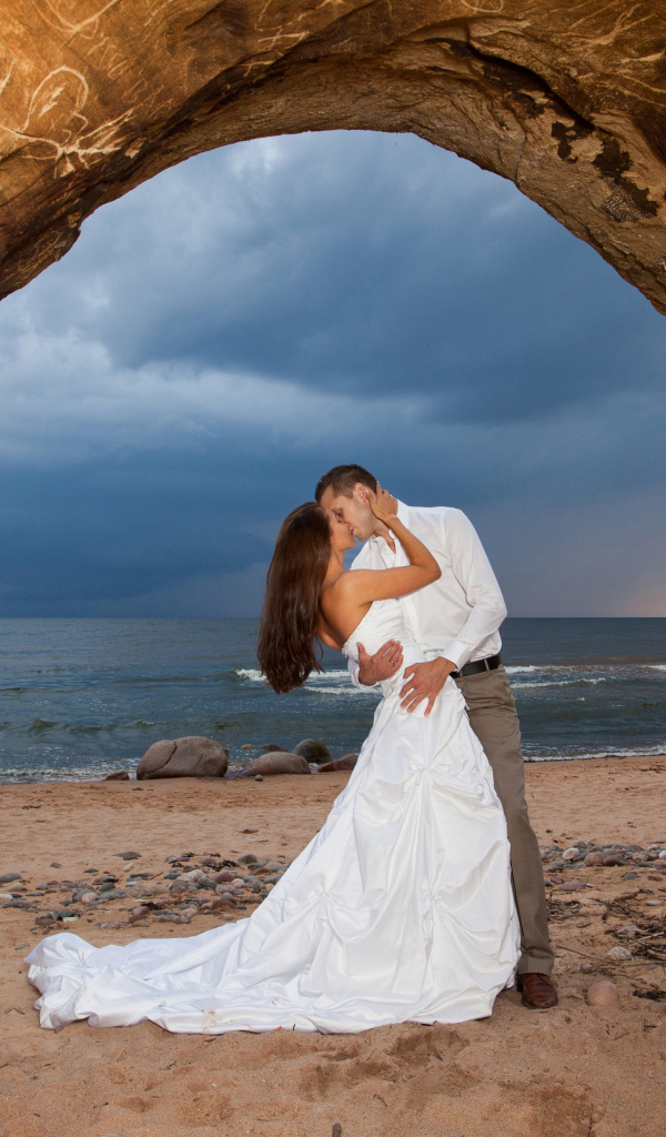 Поцелуй жениха и невесты на фоне моря