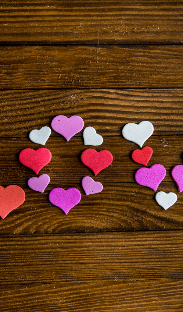 Надпись любовь из разноцветных сердец на деревянном столе