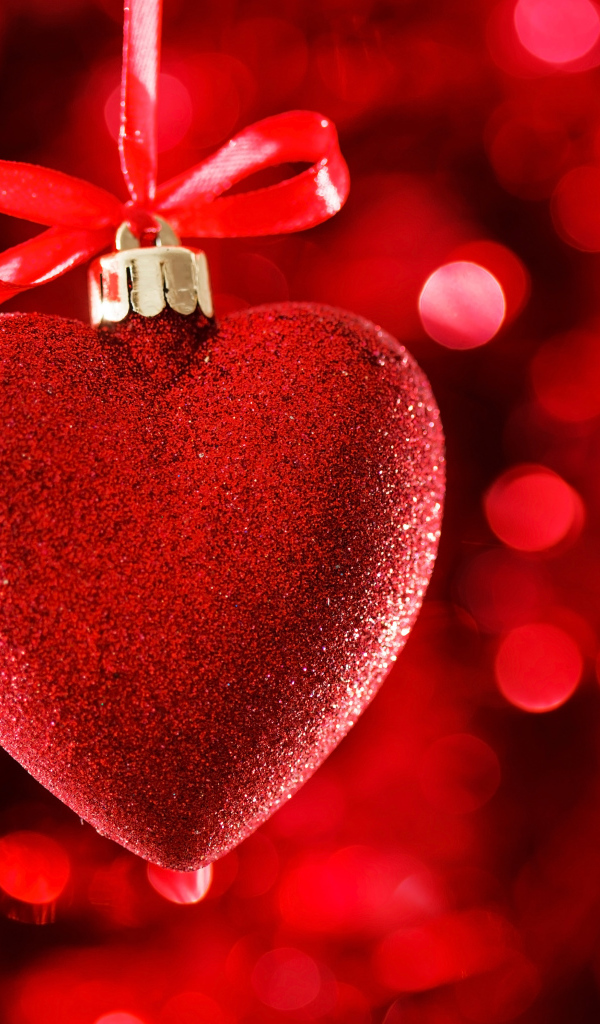 Красное большое блестящее сердце с лентой на красном фоне