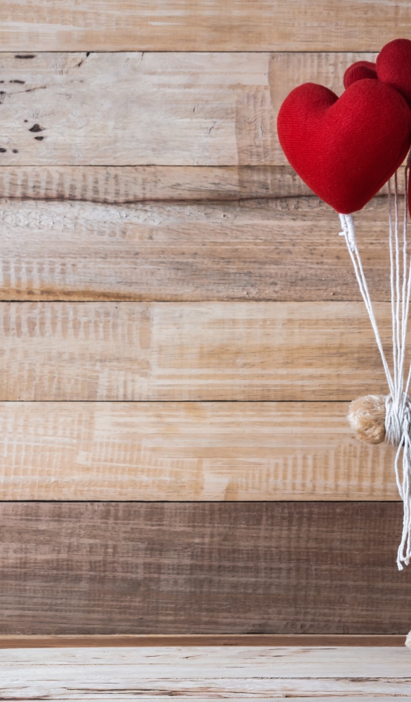 Плюшевый медведь с сердечками на деревянном фоне