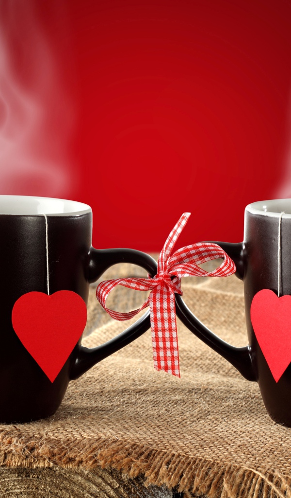 Две чашки горячего чая связаны бантом 