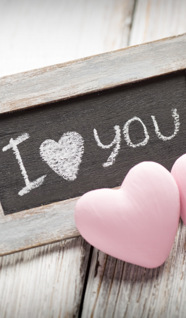 Два розовых сердца на столе с деревянной рамкой