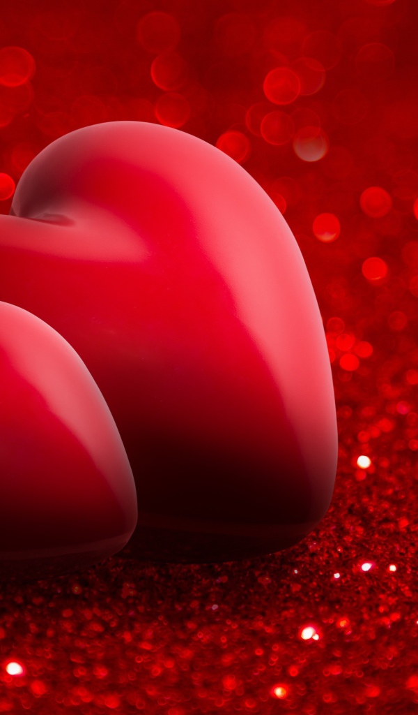 Два красных сердца на блестящем красном фоне