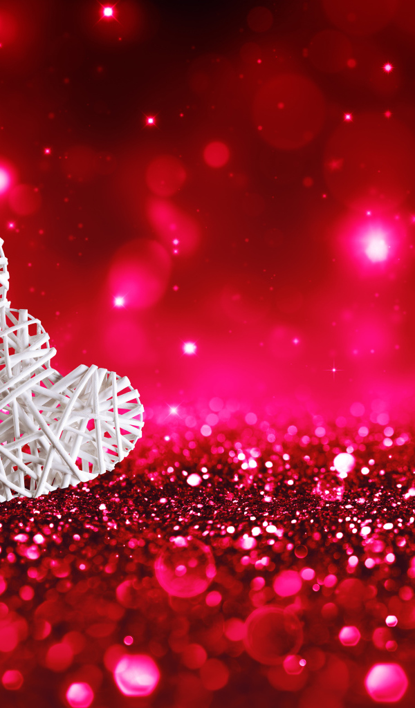 Два белых плетеных сердца на мерцающем красном фоне