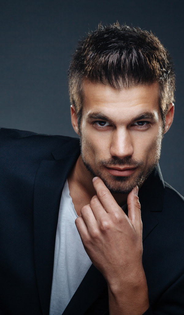 Красивый стильный мужчина в костюме на сером фоне