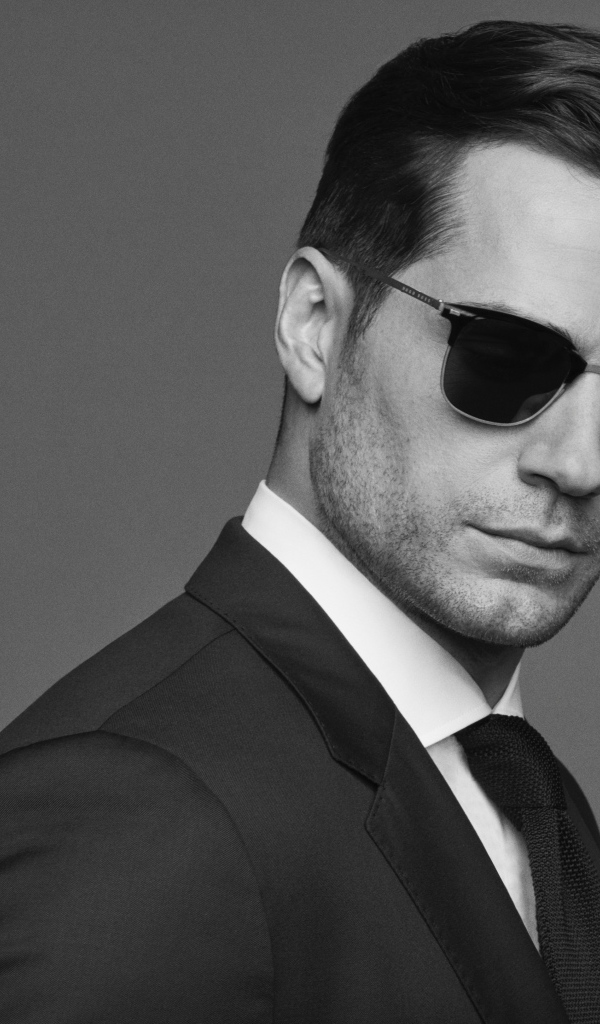 Английский актер Генри Кавилл в черных очках, черно белое фото 