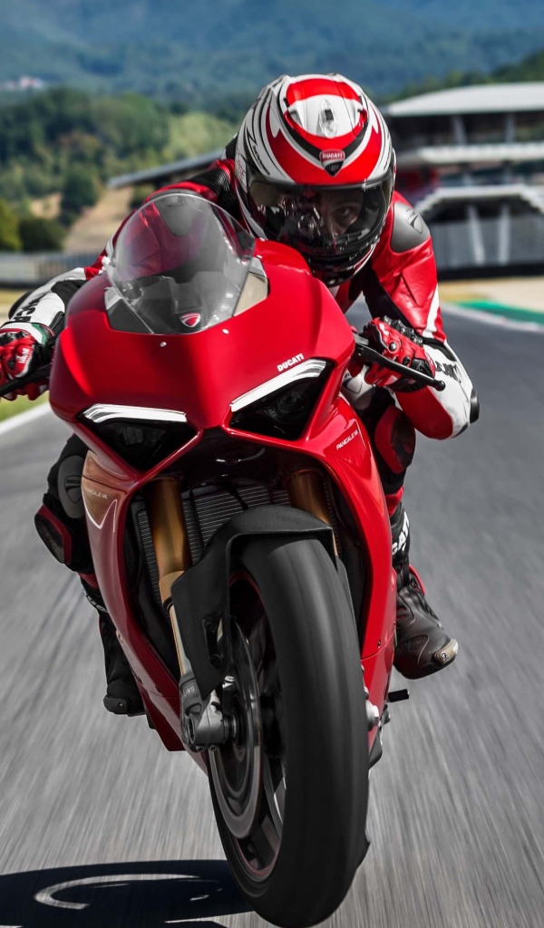 Красный мотоцикл  Ducati Panigale V4 S, 2018 на трассе с мотогонщиком