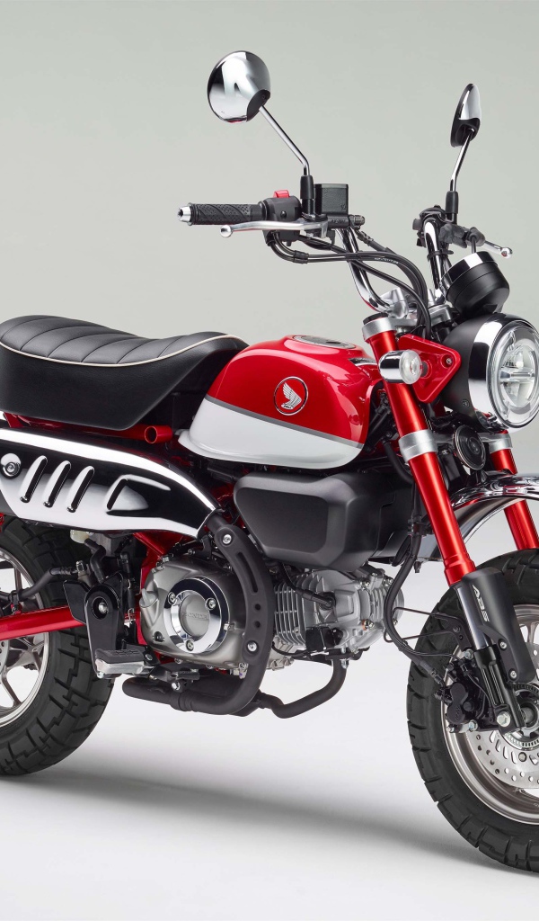 Красный мотоцикл Honda Monkey, 2018 года на сером фоне