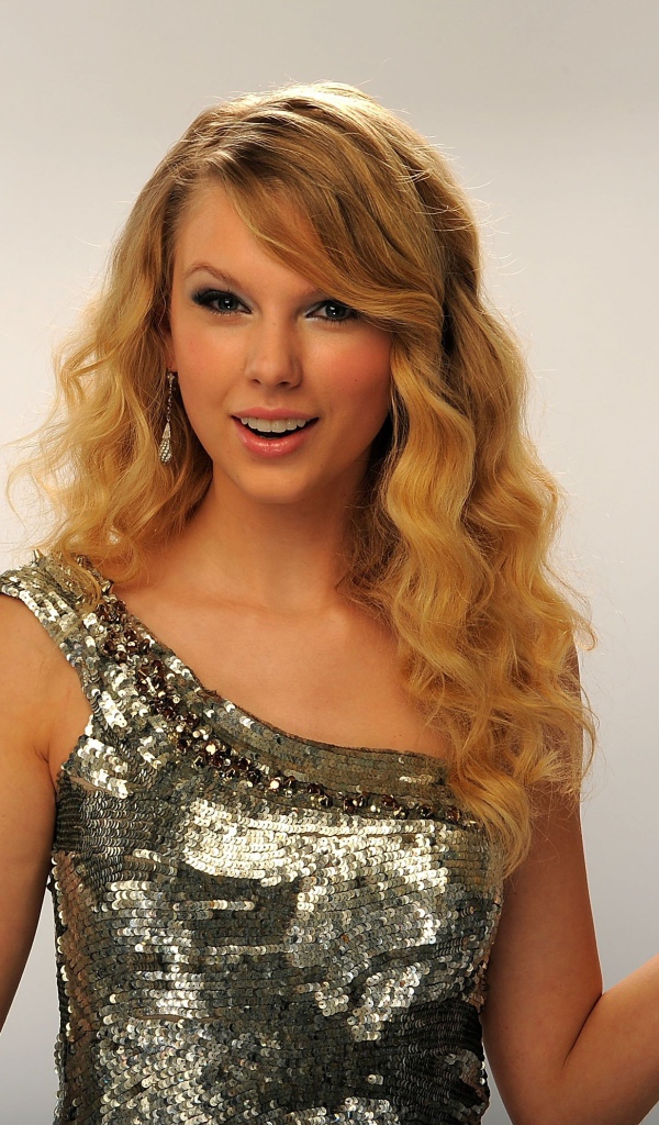 Красивая блондинка певица Тейлор Свифт с наградой в руке 