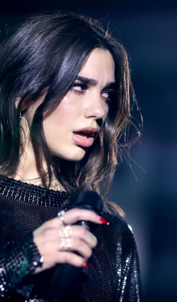 Британская певица Дуа Липа с микрофоном в руках