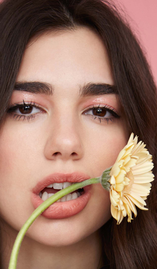 Певица Дуа Липа с цветком герберы во рту