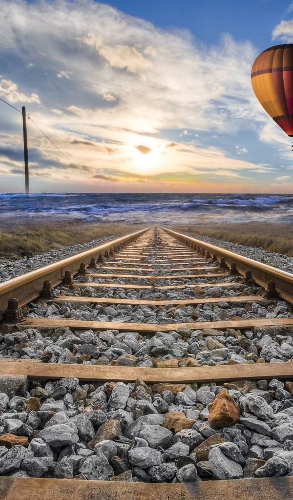 Воздушный шар в красивом голубом небе над железной дорогой