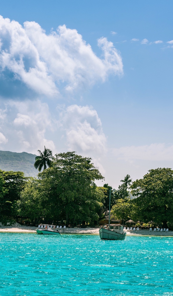 Лодки у берега острова Маэ на Сейшельских островах под красивым небом