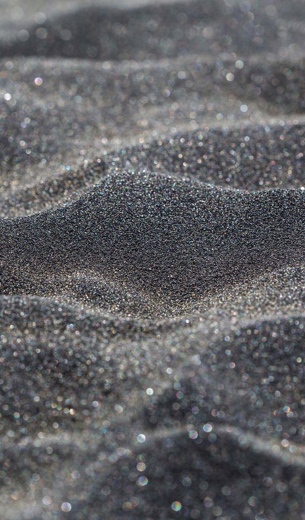 Блестящий черный песок крупным планом