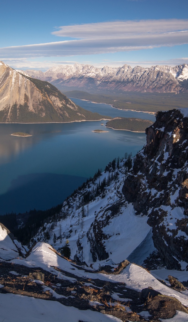 Озеро между заснеженных гор на фоне голубого неба