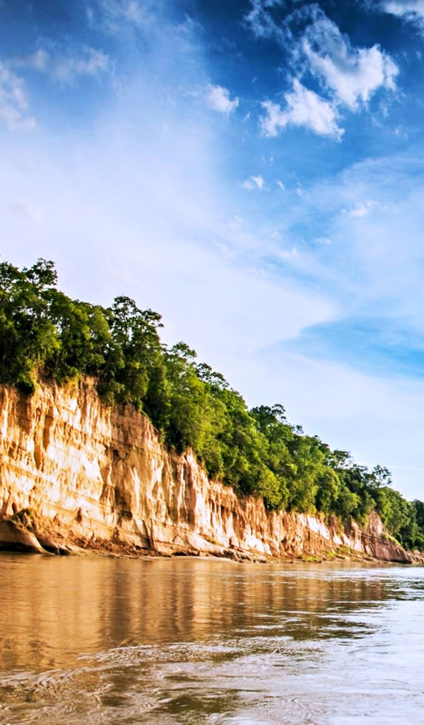 Скала на берегу реки под красивым небом