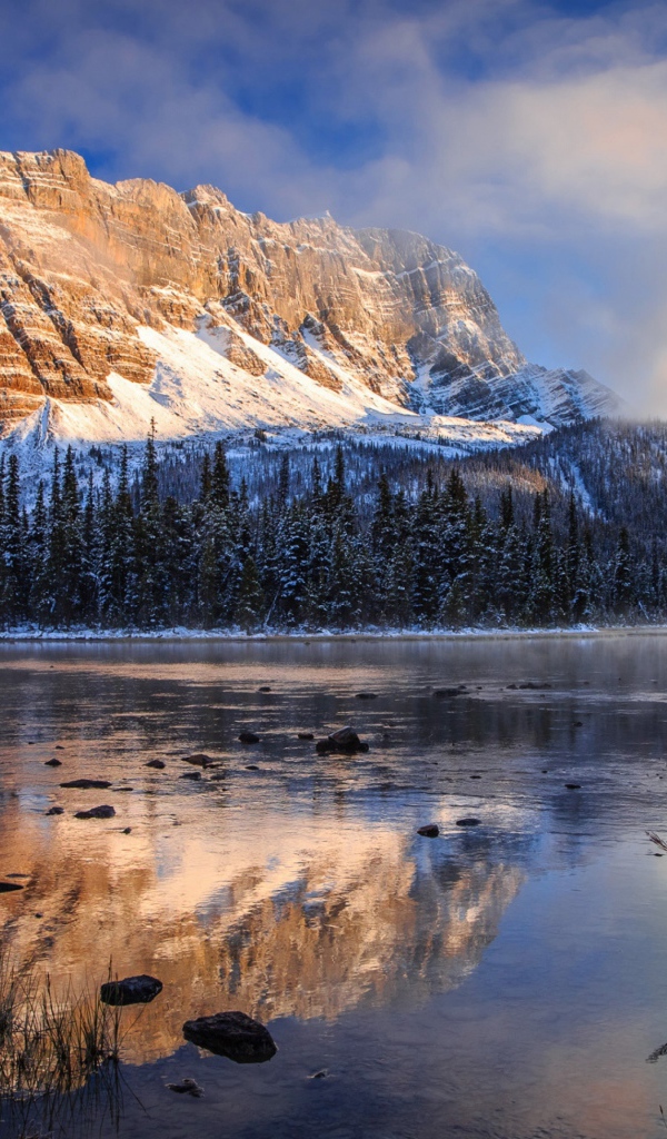 Покрытые снегом горы у заледеневшего озера