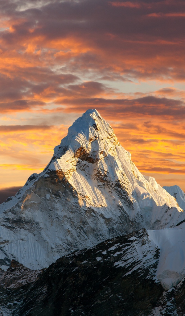 Заснеженная верхушка горы под красивым небом в лучах солнца 