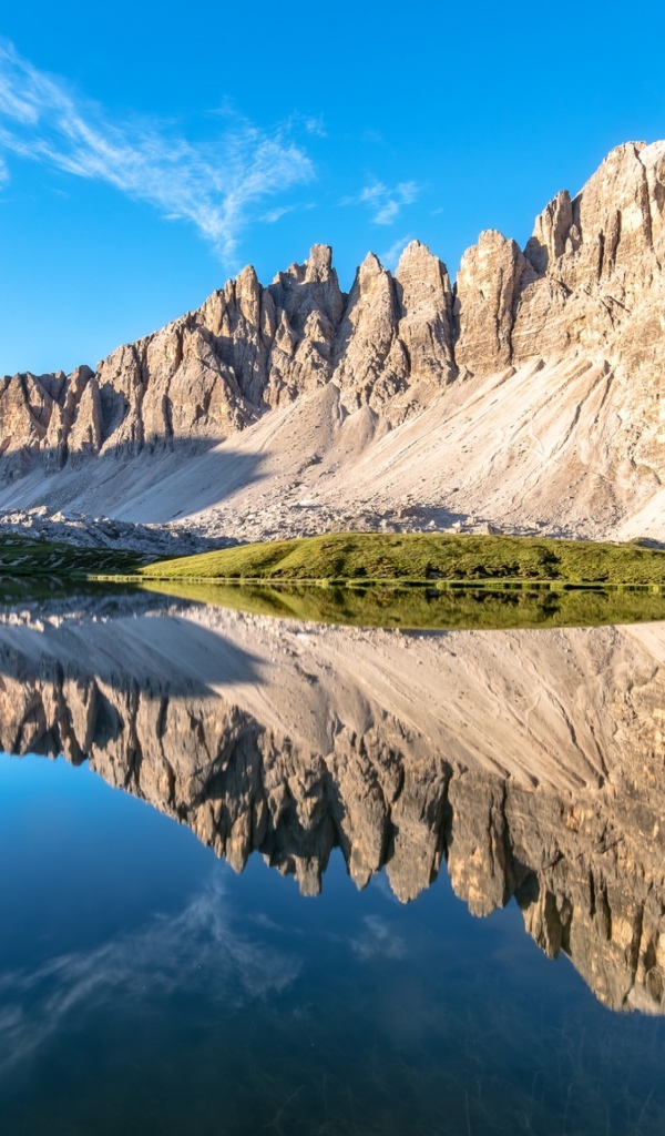 Горы и голубое небо отражаются в чистой воде 