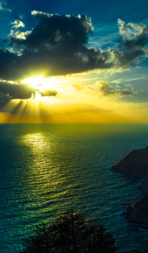 Лучи солнца пробиваются сквозь облака над океаном