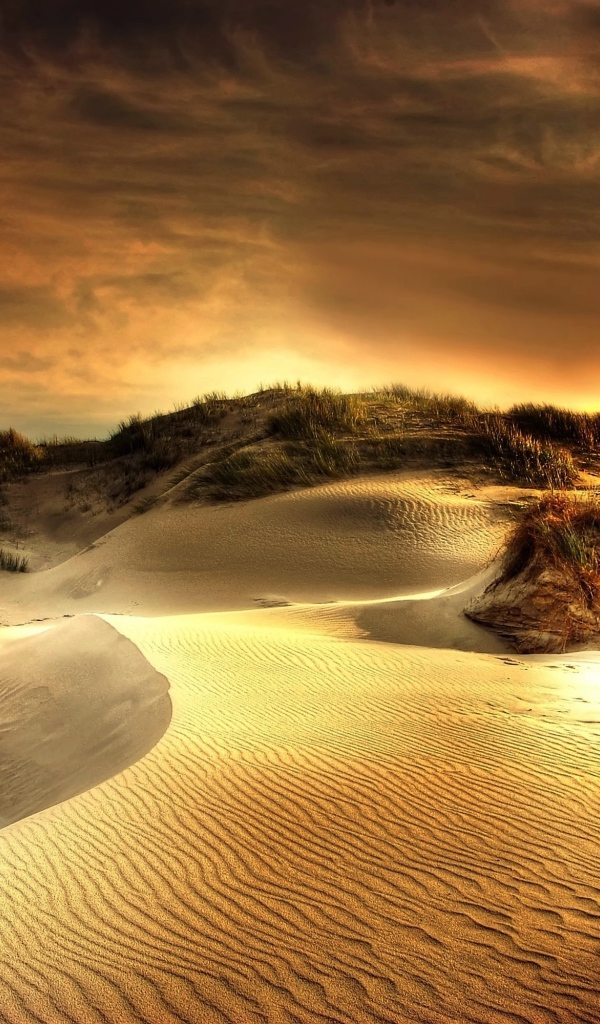 Волнистый песок под красивым небом на закате