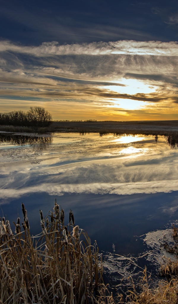 Белые облака отражаются в воде на закате солнца