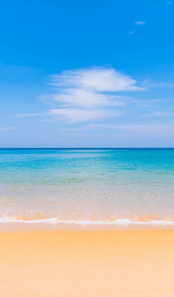 Желтый песок у лазурного океана под голубым небом