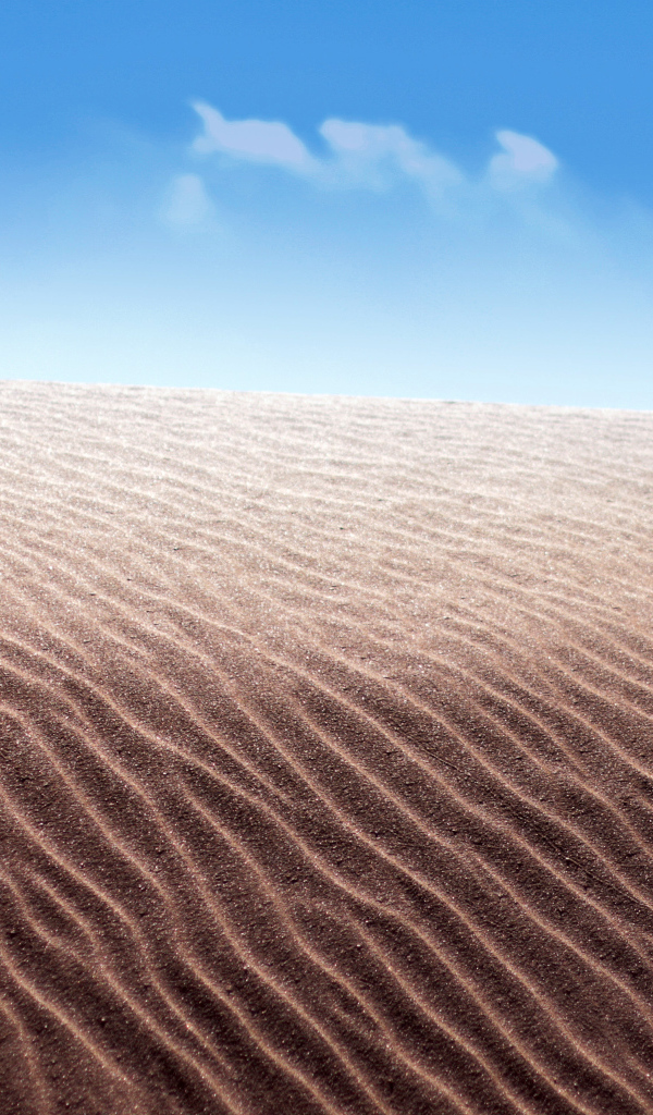 Песок в пустыне на фоне голубого неба