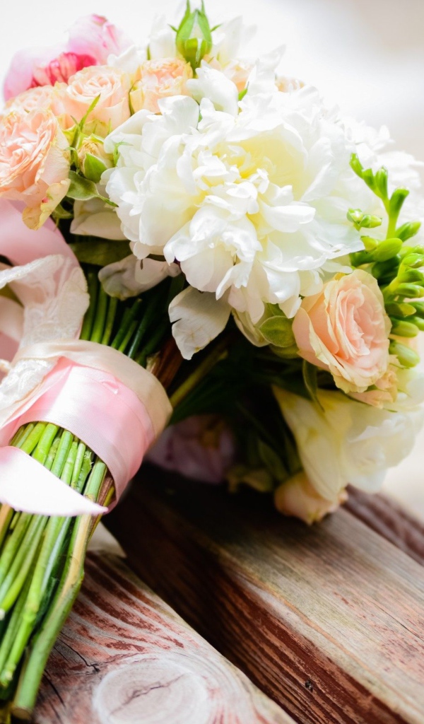 Красивый свадебный букет лежит на деревянной лавке