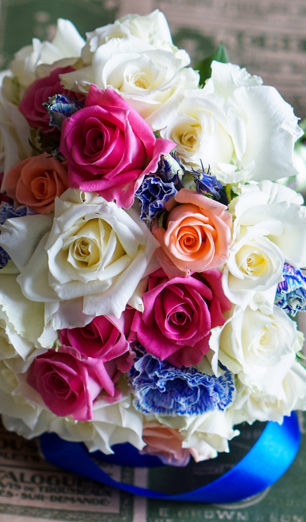 Красивый свадебный букет из роз лежит на газете