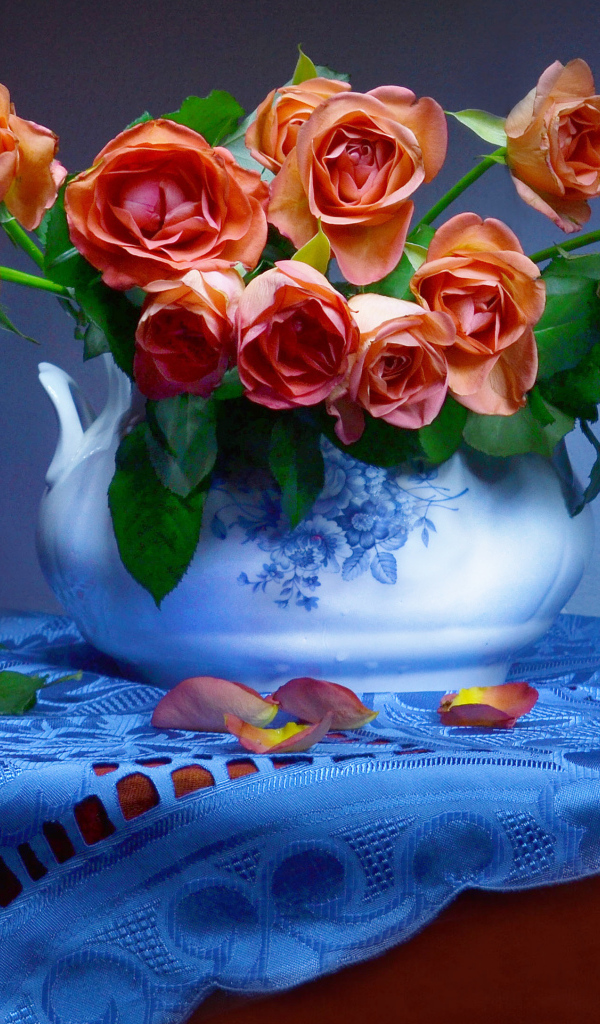 Букет оранжевых роз в вазе на столе 