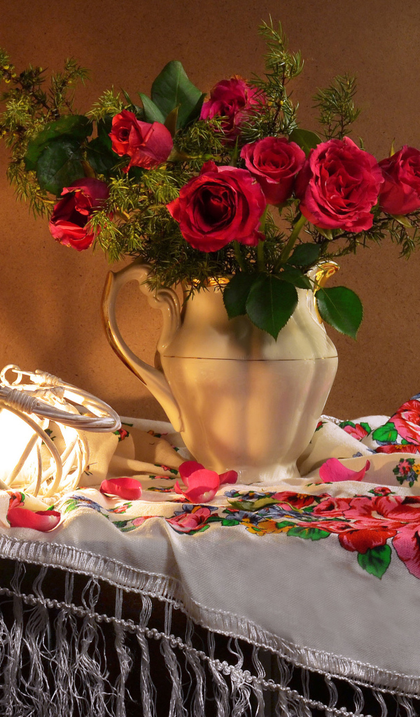 Букет роз в вазе на столе  с красивой скатертью 