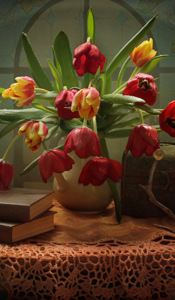 Букет тюльпанов на столе с книгами и шкатулкой