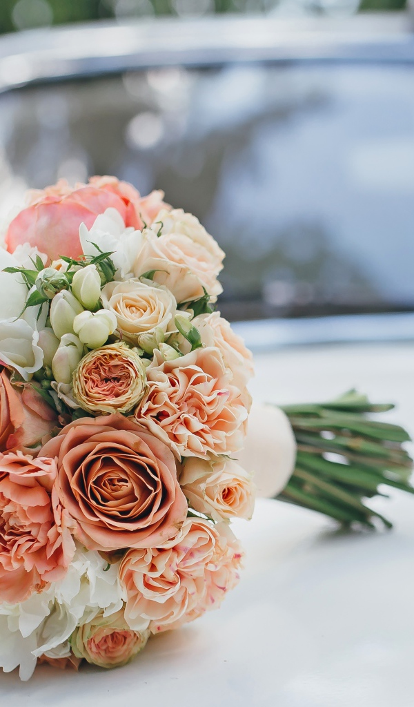 Свадебный букет роз лежит на машине