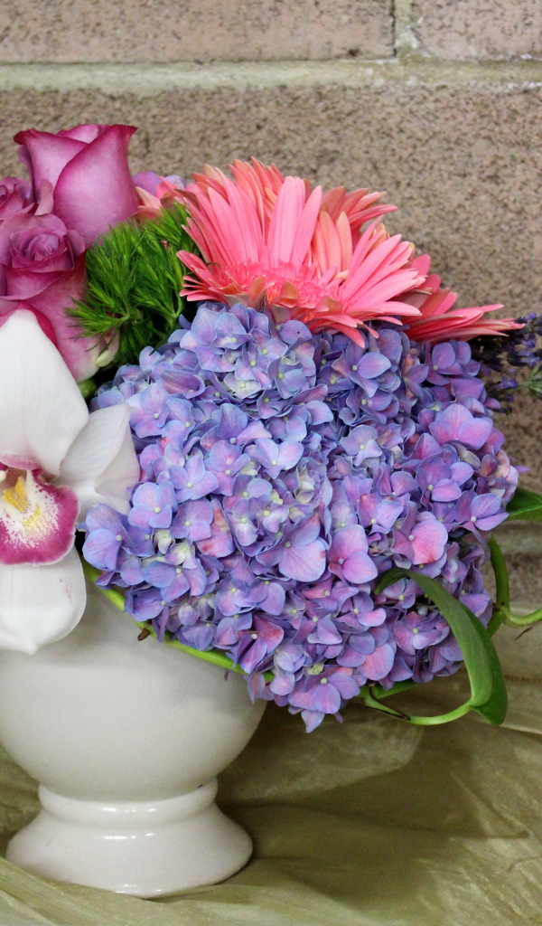 Красивый букет в белой вазе на фоне стены 