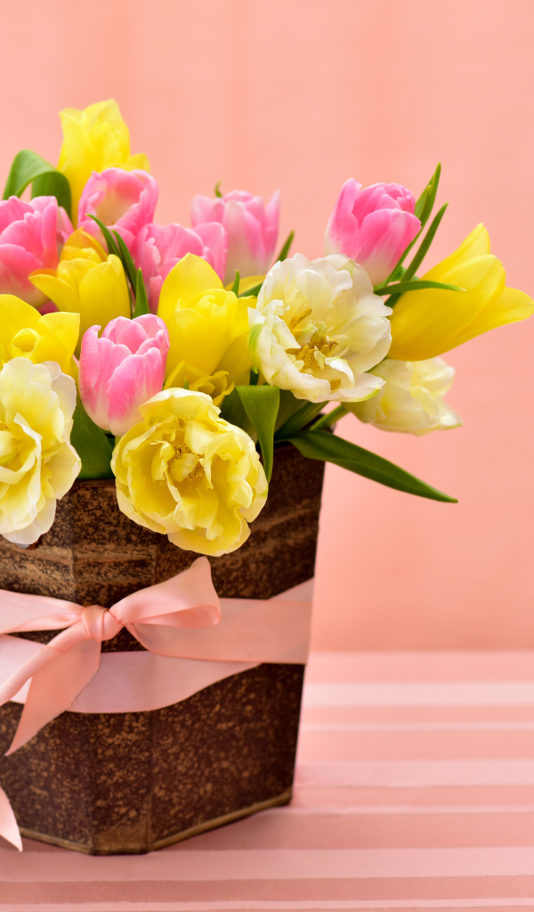 Букет красивых разноцветных тюльпанов в вазе на розовом фоне