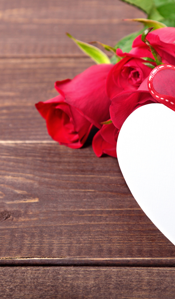 Букет розовых роз с бумажным сердцем на деревянном фоне