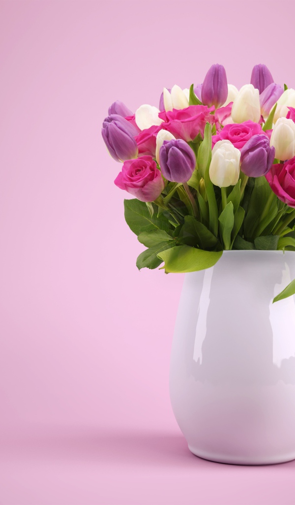 Букет тюльпанов и роз в белой вазе на розовом фоне
