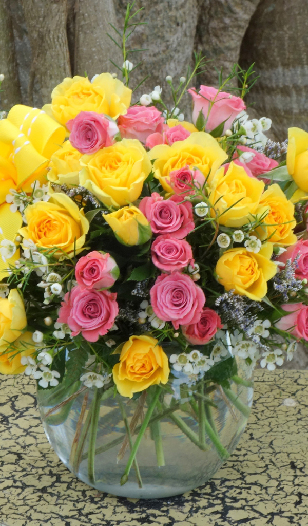 Букет желтых и розовых роз в стеклянной вазе