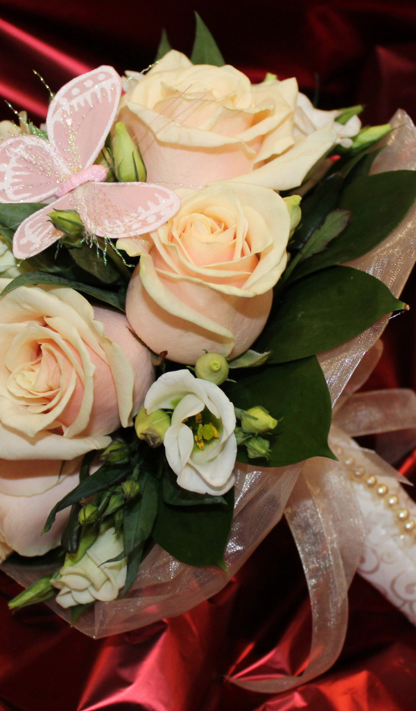 Нежный свадебный букет с цветами розовой розы и эустомы на красном фоне