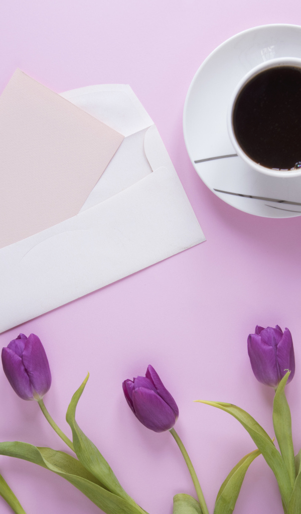 Сиреневые тюльпаны с письмом и чашкой кофе на столе 