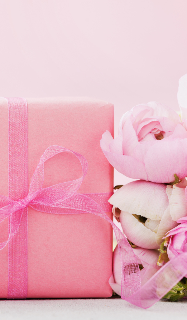 Розовый подарок с букетом розовых лютиков на розовом фоне