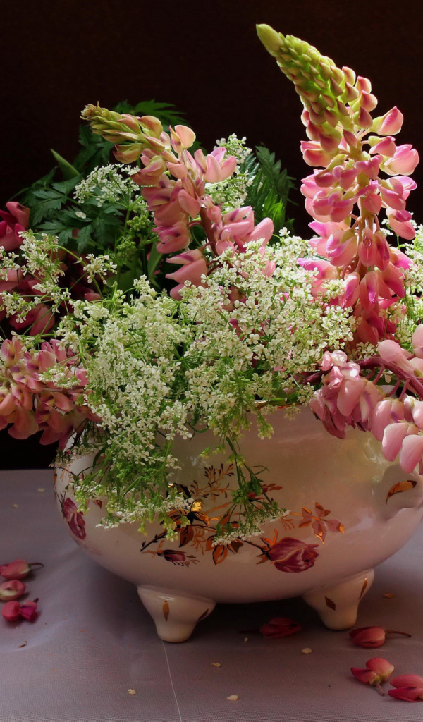 Розовые цветы люпина с полевыми цветами в вазе