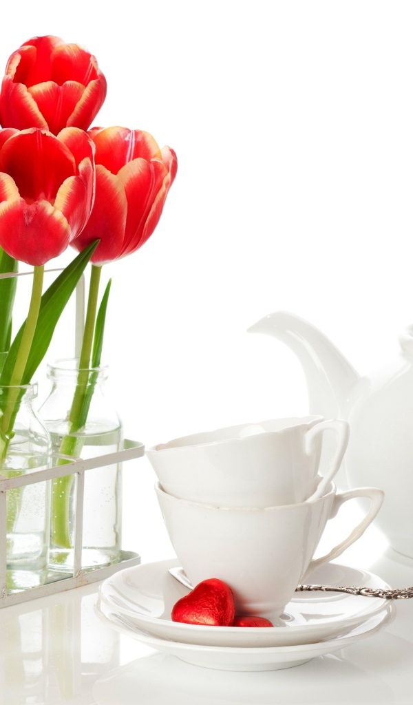 Красные тюльпаны с чайным сервизом на белом фоне