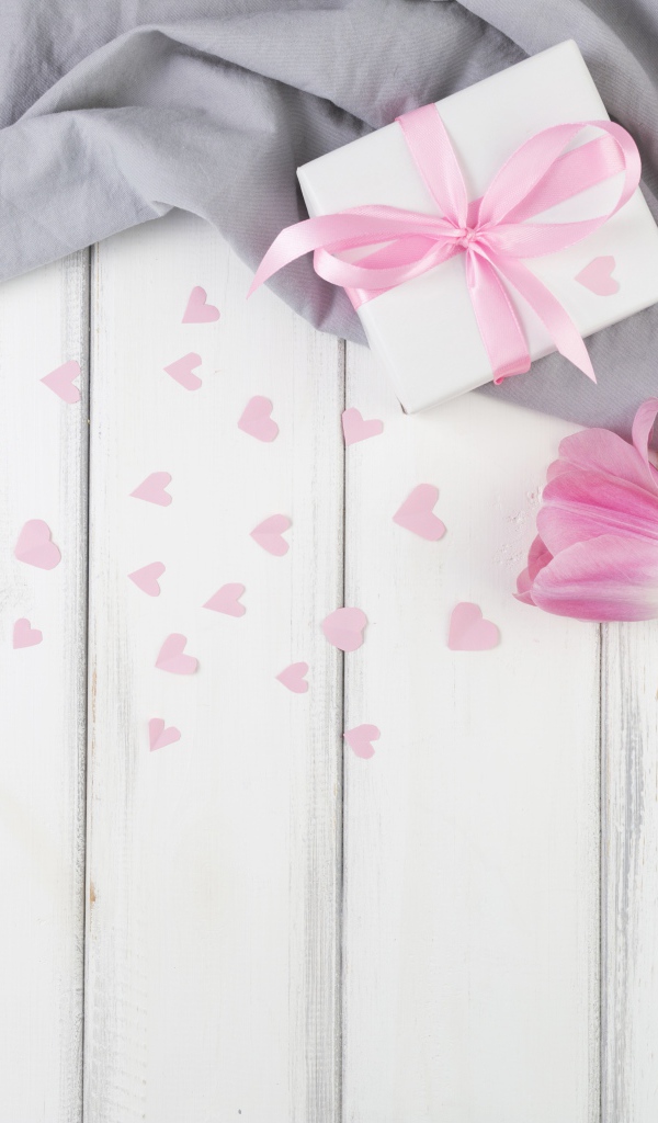 Три розовых тюльпана на столе с подарочной коробкой 